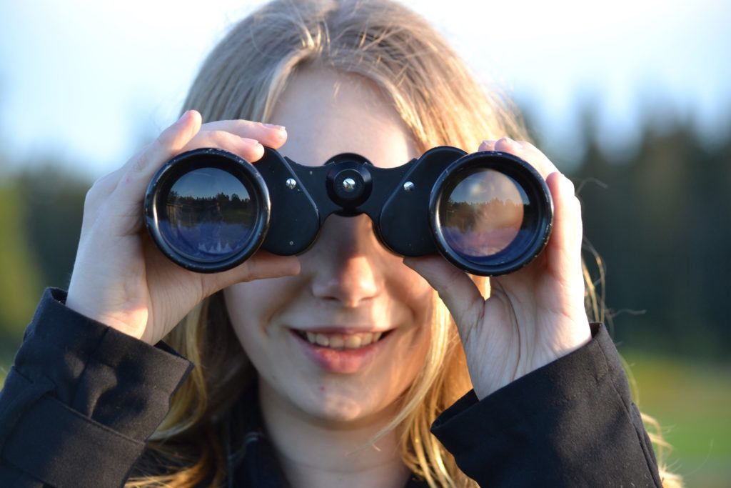 Blonde female looking through binoculars