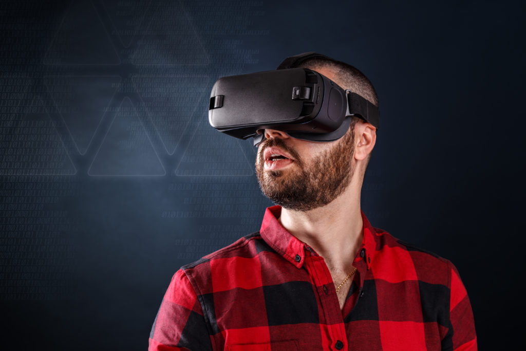 Young bearded man wearing virtual reality glasses