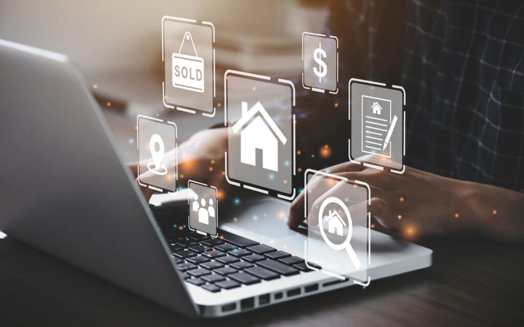 Person using laptop with real estate icons representing paid search for real estate