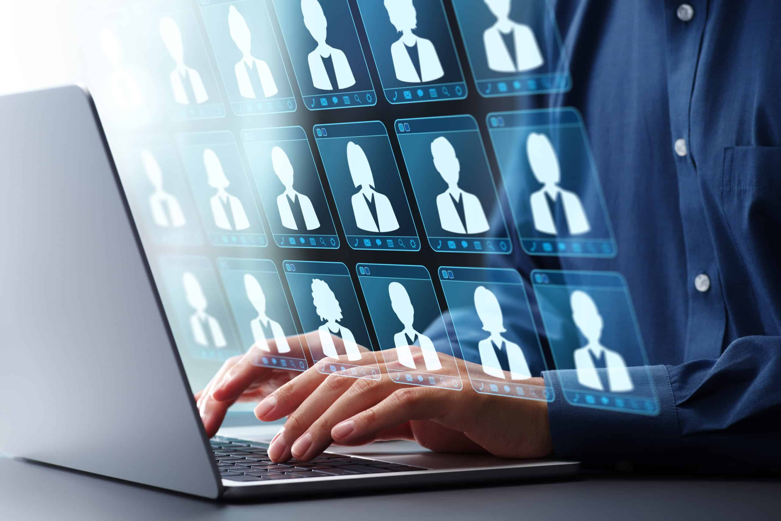 Person using laptop with digital customer profile icons on screen