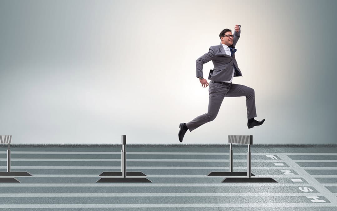 Businessman jumping over barriers in business concept.